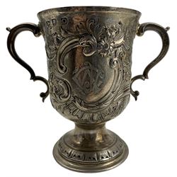 Early George III silver two handled cup with later embossed decoration and monogram, scroll handles and pedestal foot H13cm London 1769 Makers mark rubbed  