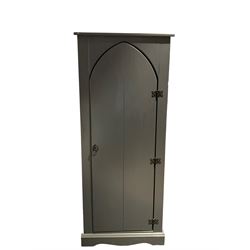 Dark grey finish cabinet enclosed by arch top door