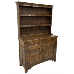 Georgian design oak dresser, two-tier plate rack with shaped aprons, the base fitted with two fielded moulded drawers, over two panelled cupboards carved with scrolling acanthus leaves, with guilloche carved central upright, on stile feet