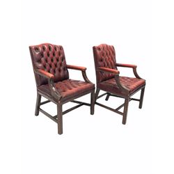 Pair of George III style library open armchairs, mahogany framed and upholstered in deep buttoned ox blood leather, raised on square moulded supports united by stretcher W66cm