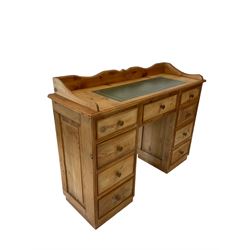 20th century pine writing desk, the raised back and leather inset top over one long and eight short drawers, raised on a plinth base 