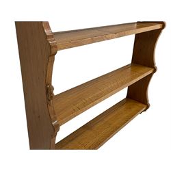 'Beaverman' oak wall hanging plate rack, moulded cornice over three shelves, shaped end supports, by Colin Almack of Sutton-under-Whitestonecliffe