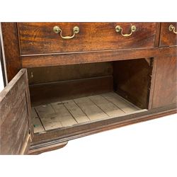 George III mahogany dresser base, rectangular top over four long drawers, two small drawers and two lower panelled cupboards, brass swan neck handles and circular handle plates, panelled sides, on ogee bracket feet