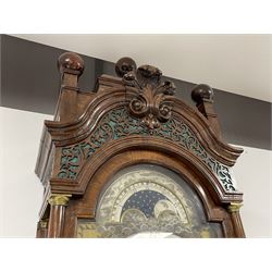 Late 18th century Dutch longcase clock by Pieter Swann, Amsterdam. In a walnut case with swan’s neck pediment and raised caddy top surmounted with three wooden ball finials, silk backed fretwork frieze to the front and sides and corresponding sound frets to both sides of the hood, break arch hood door with attached pilasters and brass capitals, trunk with concave corners and conforming long break arch door with raised beading to the edge and incorporated  glass lenticle with a brass bezel, trunk on a square crossbanded plinth with applied bombe base, brass break arch dial with an engraved surround, silvered and engraved moon disc recording the lunar date and times of high water at Amsterdam, cast four seasons spandrels, silvered chapter ring with Roman numerals, five-minute Arabic’s, minute and quarter hour tracks, matted and engraved dial centre with ringed winding collets and alarm disc, subsidiary day, date and seconds dials, with finely pieced and fettled steel hands, dial pinned directly to an eight-day weight driven movement striking the alarm, hours and half hours on two bells. With two brass cased weights and pendulum.



