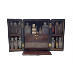 Early 19th century mahogany apothecaries cabinet enclosed by pair of divided front doors, the interior with two drawers and fitted with many original items including labelled and plain bottles, balance scales, glass pestle and mortar etc, the case with countersunk brass handle W21cm x H27cm x D18cm