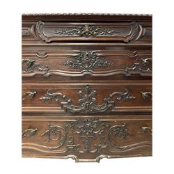 Early 20th century French design commode or chest, serpentine form with gardroon and foliate carved top, fitted with small frieze drawer over three long graduating drawers, the fronts carved with extending scrolled leafy stems, the sides decorated with foliate cartouche shields on cross-hatch ground, canted upright corners carved with acanthus leaves 