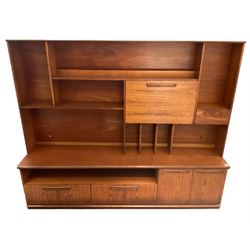 Meredew - mid-20th century teak wall unit, the raised top fitted with fall front, small drawer, shelves and record divisions, enclosed by sliding glass doors, the lower section fitted with two drawers and double cupboard