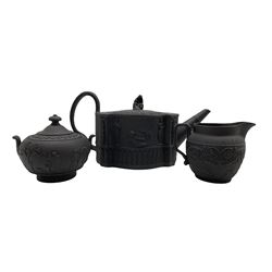 19th century black basalt teapot with female knop handle and the body moulded with Classical figures H13.5cm, together with matched Wedgwood milk jug and sucrier (3)