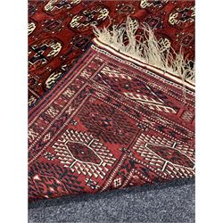 Persian Bokhara red ground carpet, with gul motif on central field and stylised geometric design to border324cm x 225cm