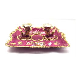 19th century Rockingham style porcelain inkstand, hand-painted with spring flowers on pink ground within a moulded gilt scroll border, with two cornucopia shaped holders to the centre, L34cm