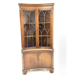 Georgian style mahogany concave fronted corner cabinet, with dentil cornice over astragal glazed doors enclosing two shelves,  cross banded cupboard doors under, raised on shaped bracket supports, W92cm, H190cm, D63cm