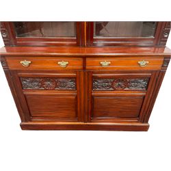 Late 19th century walnut bookcase on cupboard, the projecting cornice over two glazed doors, enclosing three adjustable shelves over two drawers and two cupboard doors, raised on a plinth base 