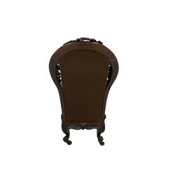 Victorian rosewood nursing chair, the fruit and foliate carved frame and upholstered seat and back, raised on cabriole supports with brass castors  