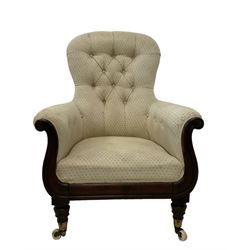 William IV rosewood framed library armchair, spoon shaped back with scrolled arms carved with rosette decoration, upholstered in buttoned cream fabric with sprung seat, raised on turned supports terminating in brass cups and ceramic castors