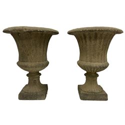 Pair of large Victorian design cast stone garden urns, Campana shape with fluted body over gadrooned underbelly, circular footed base