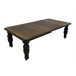 Victorian oak extendable dining table, the extending top with carved edge over profusely carved turned supports, terminating in ceramic castors 