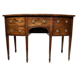 19th century mahogany bowfront sideboard fitted with central frieze drawer flanked by a deep cellaret drawer and a cupboard door, with faux drawer fronts, raised on square tapering legs with spade feet