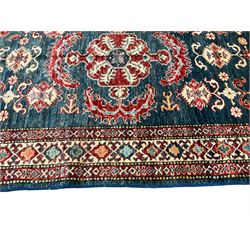 Persian indigo ground rug, the central crimson medallion with extending patterns, surrounded by geometric floral designs, guarded border with repeating decoration