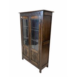 Early 20th century oak bookcase, lunette carved frieze over two lead glazed doors with lozenge carved panels enclosing three shelves, raised on stile supports W75cm