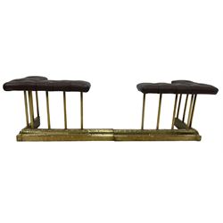 Victorian and later brass club fire fender in two sections, the corner seats upholstered in buttoned brown leather over plain spokes, the hammered base decorated with reeding and acanthus leaves, each base W66cm D36cm