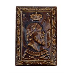 Early 20th century commemorative tile paperweight, of rectangular form with bevelled edges, in treacle glaze, decorated in relief with a bust of Tennyson, 'Born 1809, Died 1899', possibly by Minton Hollins & Co, L12.5cm 
