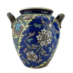 Burmantofts Faience twin-handled Anglo-Persian vase, designed by Leonard King, of ovoid form with applied loop handles and painted with stylized flowers and foliage against a blue and yellow ground, impressed factory marks no. 69, incised D.230, 1666 and artists monogram LK, H24.5cm 