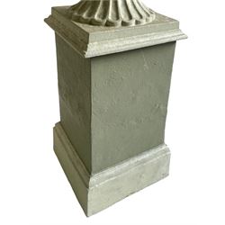 Pair of cast iron two-piece garden urns on plinths, egg and dart moulded rim over gadrooned underbelly, moulded footed base, on tapered square plinth