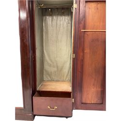 Victorian mahogany breakfront triple wardrobe, the projecting cornice over one central mirror and two doors, opening to reveal interior fitted for hanging raised on castors 