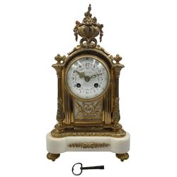 Cherillier - Paris, late 19th century brass cased 8-day mantle clock on a white marble base, break arch top with non matching finials surmounted by an oval bowl festooned with flowers, enamel dial with retailers name, Arabic numerals and floral swags, pierced Louis XV gilt hands within a convex glass and brass bezel, twin train rack striking movement striking the hours and half hours on a bell. With key and pendulum.  
