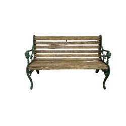 Garden bench with green decorative cast iron ends and slat seat and back 