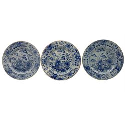 Three 18th century Delft tin glazed earthenware plates, centrally painted with bamboo and rockwork within floral borders, D22cm
