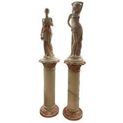 Near pair marbled statues of a Dancing Girl and Classical Maiden on pedestal columns with lights H154cm