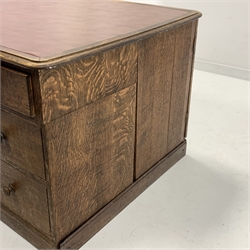 19th century oak estate twin pedestal desk, skivered top over one long drawer and two banks of three short graduating drawers, opposite panelled cupboards enclosing two banks of four slides, on skirted base, 164cm x 100cm, H80cm