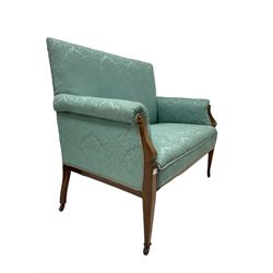 Edwardian mahogany two seat settee, the show frame with boxwood and satinwood inlay, upholstered in blue floral damask silk fabric, raised on square tapered supports with brass and ceramic castors W125cm