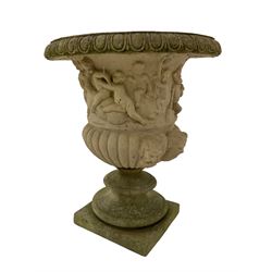 Composite stone Campana shaped garden urn, the egg and dart edge over a relief frieze depicting mischievous putti and bacchic celebration, the gadrooned bowl with horned satyr masks