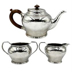 Silver three piece tea set of circular form, the tea pot with stained handle and lift London 1934 33oz
