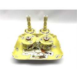 19th Century Berlin inkstand painted with panels of birds and insects on a yellow ground with inkwell and caster 25cm x 19cm (seconds leaf mark) and a pair of yellow ground candlesticks painted with landscape and floral panels on an hexagonal base H13cm with crossed swords mark