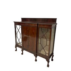 Edwardian mahogany breakfront display cabinet, the raised back over one cupboard enclosing two fixed shelves, flanked by two glazed doors of astragal design, raised on ball and claw feet 