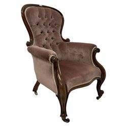 Victorian armchair, the scrolled show frame over buttoned back pink fabric, raised on cabriole supports, terminating in castors
