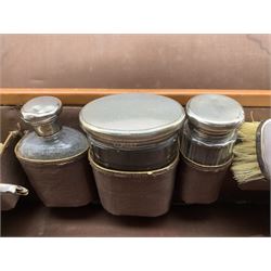 1920's travelling dressing case with fitted interior comprising three cut glass dressing table jars with silver tops by Cole Brothers, London, 1927, together with two brushes by the same maker, contained in tan leather case, L56cm