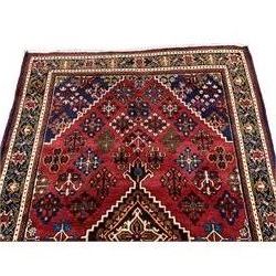 Persian Joshagan crimson ground rug, the field with a central lozenge medallion, surrounded by stylised tree of life and floral motifs with contrasting indigo spandrels, the guarded border with repeating scrolling palmettes