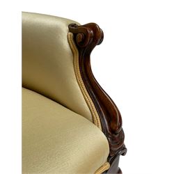 Victorian walnut armchair, curved back with moulded frame, upholstered in pale yellow fabric, scroll carved arm terminals and shaped uprights, cabriole supports on brass castors, sprung seat 