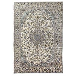 Persian ivory ground carpet, overall floral design with central medallion, the field decorated with scrolling branches and stylised plant motifs, repeating border within guard stripes