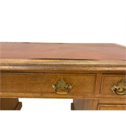 20th century oak writing desk, the leather inset top and three frieze drawers over six graduated drawers, raised on a plinth base