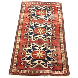  Caucasian style rug, with triple geometric medallion on red field, 112cm x 197cm  