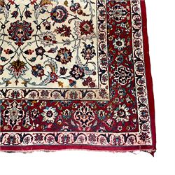 Persian Isfahan ivory ground finely woven rug, the busy field decorated with central pole medallion surrounded by scrolling foliate tendrils with stylised palmettes, the guarded border with repeating curls of floral motifs and leafage