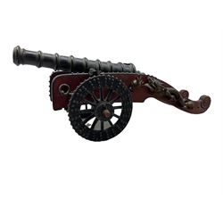 19th/ early 20th century Chinese style patinated bronze model of a cannon, of tapered form with a number of raised bands, on a metal bound red-stained field carriage mounted with gilt dragons on the cheeks and fitted with a pair spoked wheels, L50cm overall, cannon L35cm
