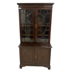 George III figured oak bookcase on cupboard, two astragal glazed doors enclosing adjustable shelves, the base fitted with double panelled cupboard, lower moulded edge on bracket feet