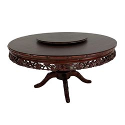 Circular rosewood dining table over one turned pillar leading into four splayed supports, together with lazy Susan and eight chairs with loose cushions
