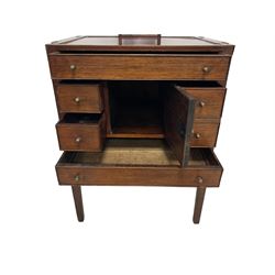 George III mahogany enclosed washstand, the twin hinged rectangular top enclosing flat surface, pull-out mirror with rectangular plate and turned bone handles, fitted with single cupboard door surrounded by five drawers with cock-beaded facias, raised on square tapering supports